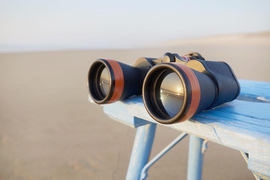 A pair of binoculars on a beach.